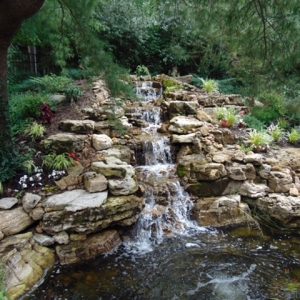 Long stream with multiple waterfalls flowing to a beautiful pond